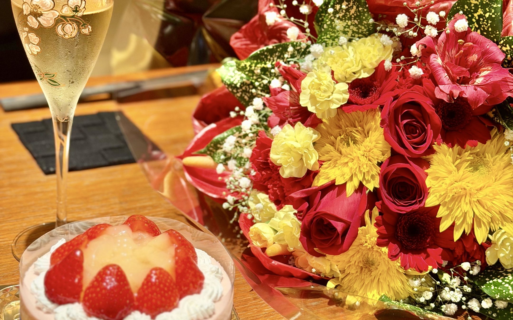 記念日のケーキと花束、スパークリングワイン